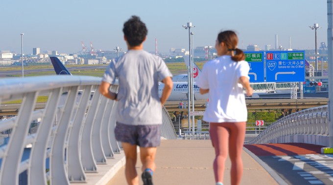 羽田空港近隣でランニングをするカップルの画像