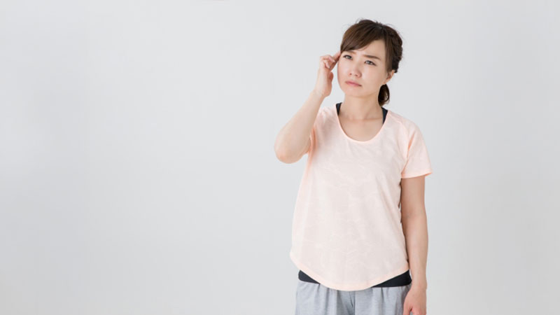 頭部を気にしている女性